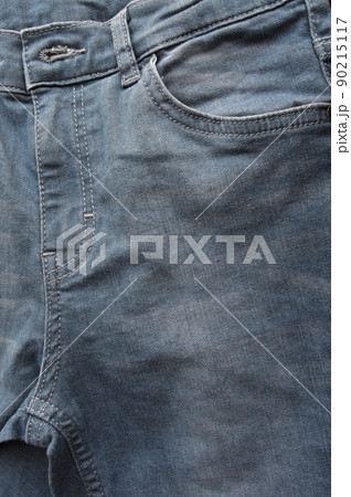 Zipper pocket and buttons close-up detail of light blue jeans 90215117