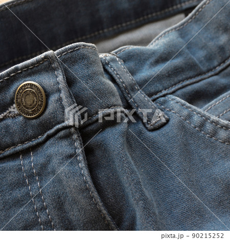 Close up detail of pocket and buttons front view of light blue jeans 90215252