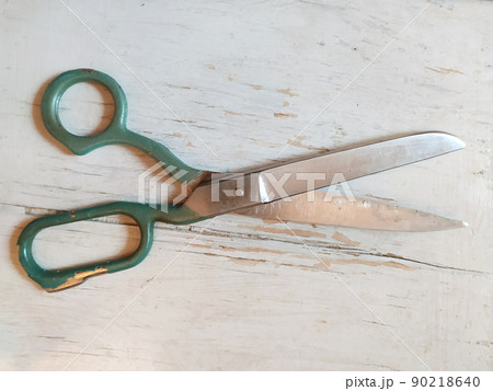 Old tailor big scissors on a wooden white background. Vintage object. 90218640