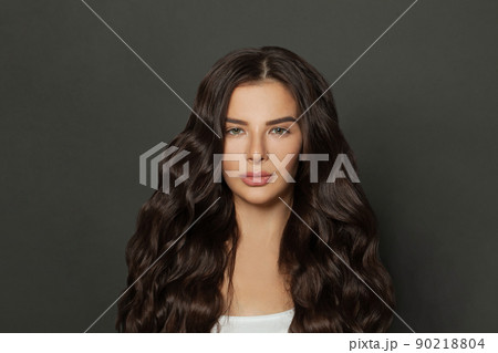 Beautiful woman with long wavy coloring hair on black background. 90218804
