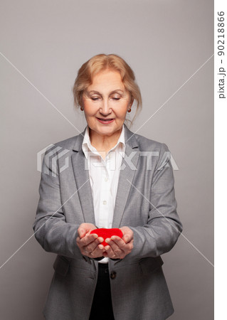 Senior woman with red heart in her hands Senior woman with red heart in her hands 90218866
