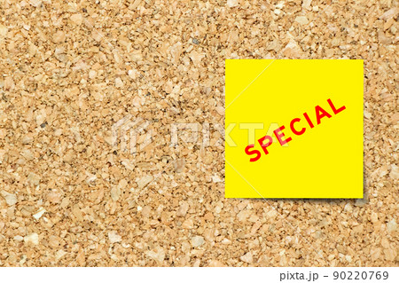 Yellow note paper with word special on cork board background with copy space 90220769