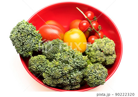 Composition of vegetables in bowl. Broccoli, red and yellow tomatoes 90222320