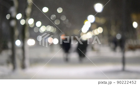 Blurred background. City view, lights, falling snow, night, street, bokeh spots of headlights of moving cars. Diffuse Urban backdrop winter scenery of street in city at night. Lantern light, snowfall Blurred background. City view, lights, falling snow, night, street, bokeh spots of headlights of moving cars. Diffuse Urban backdrop winter scenery of street in city at night. Lantern light, snowfall 90222452