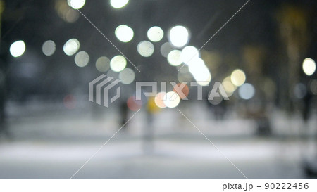 Blurred background. City view, lights, falling snow, night, street, bokeh spots of headlights of moving cars. Diffuse Urban backdrop winter scenery of street in city at night. Lantern light, snowfall Blurred background. City view, lights, falling snow, night, street, bokeh spots of headlights of moving cars. Diffuse Urban backdrop winter scenery of street in city at night. Lantern light, snowfall 90222456