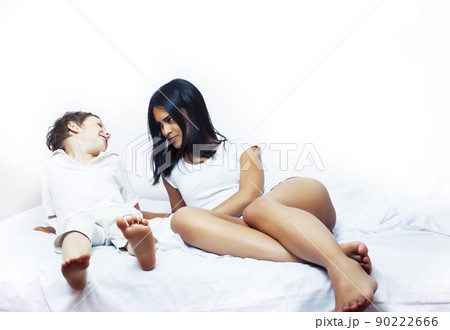 cute little boy in bed with mother in pajamas having fun happy smiling, lifestyle people concept close up 90222666