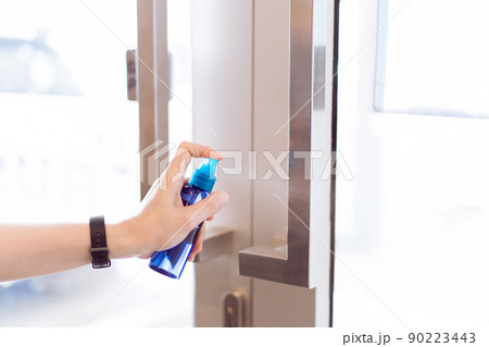 Unrecognizable Asian woman using an alcohol or liquid sanitizer spraying on the door handle before touching, alway using sanitizer to protect and prevent from COVID-19 pandemic. Coronavirus disease. Unrecognizable Asian woman using an alcohol or liquid sanitizer spraying on the door handle before touching, alway using sanitizer to protect and prevent from COVID-19 pandemic. Coronavirus disease. 90223443