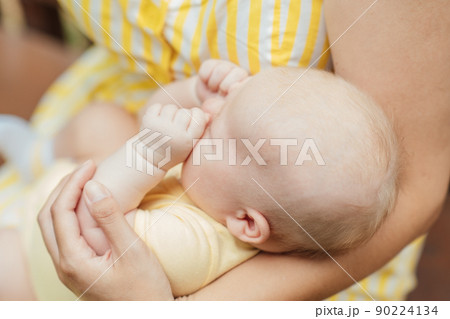 Newborn Baby Skin Care. Close up Mother holding newborn baby in hands on nature background. Outdoor portrait of mother with infant child son. Newborn Baby Skin Care. Close up Mother holding newborn baby in hands on nature background. Outdoor portrait of mother with infant child son. 90224134