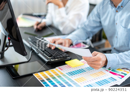 Two creative graphic designer team working on color selection and drawing on graphic tablet, Color swatch samples chart for selection coloring in inspiration to creativity at workplace 90224351