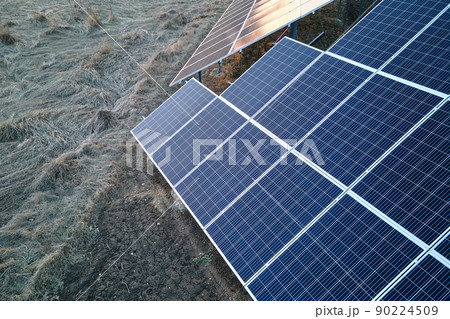 Solar photovoltaic panels mounted on stand-alone frame on backyard ground for generating of clean ecological electric energy. Concept of autonomous house Solar photovoltaic panels mounted on stand-alone frame on backyard ground for generating of clean ecological electric energy. Concept of autonomous house 90224509