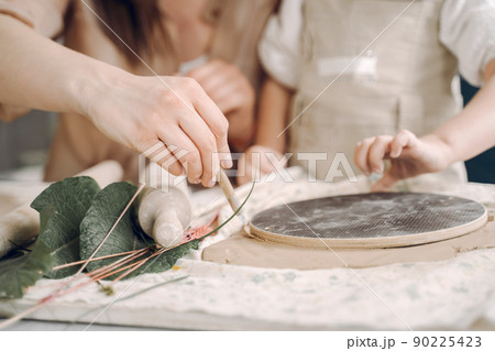 Woman and girl kneading clay. Family make art product at table in pottery workshop. Mother with daughter. Woman and girl kneading clay. Family make art product at table in pottery workshop. Mother with daughter. 90225423