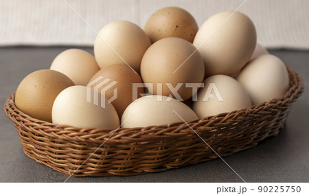 Farm chicken eggs. Lots of eggs in a wicker basket close up. Farm chicken eggs. Lots of eggs in a wicker basket close up. 90225750