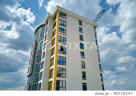 Architectural details of modern high apartment building facade with many windows and balconies Architectural details of modern high apartment building facade with many windows and balconies 90226347