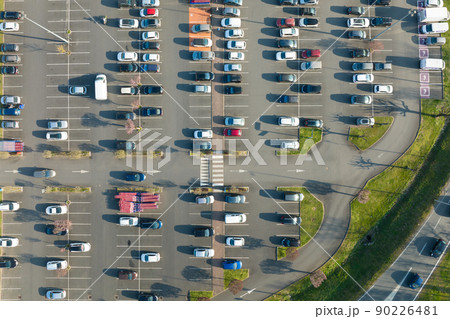 Aerial view of many colorful cars parked on parking lot with lines and markings for parking places and directions Aerial view of many colorful cars parked on parking lot with lines and markings for parking places and directions 90226481