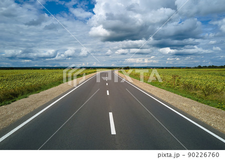 Aerial view of empty intercity road between green agricultural fields. Top view from drone of highway roadway Aerial view of empty intercity road between green agricultural fields. Top view from drone of highway roadway 90226760