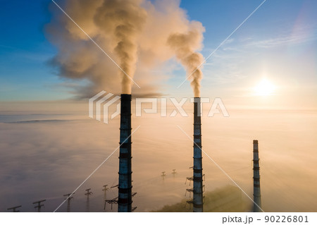 Aerial view of coal power plant high pipes with black smoke moving up polluting atmosphere at sunrise. Aerial view of coal power plant high pipes with black smoke moving up polluting atmosphere at sunrise. 90226801