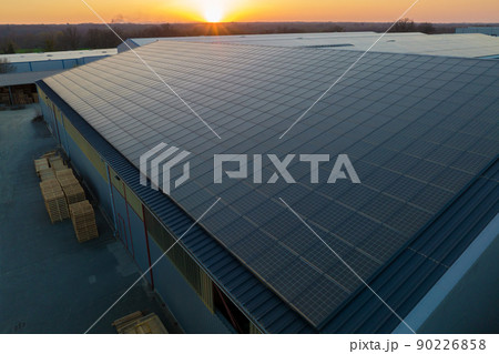 Aerial view of blue photovoltaic solar panels mounted on industrial building roof for producing green ecological electricity. Production of sustainable energy concept Aerial view of blue photovoltaic solar panels mounted on industrial building roof for producing green ecological electricity. Production of sustainable energy concept 90226858