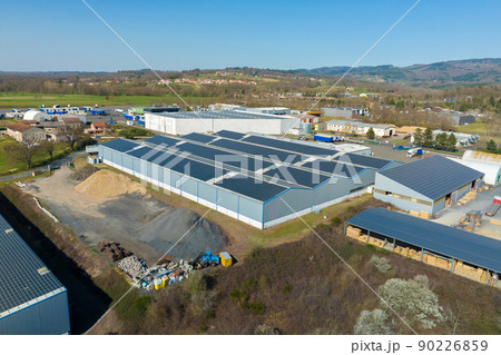 Aerial view of blue photovoltaic solar panels mounted on industrial building roof for producing green ecological electricity. Production of sustainable energy concept 90226859