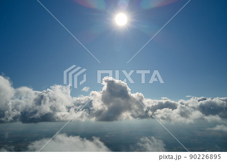 Aerial view from airplane window at high altitude of earth covered with puffy cumulus clouds forming before rainstorm Aerial view from airplane window at high altitude of earth covered with puffy cumulus clouds forming before rainstorm 90226895