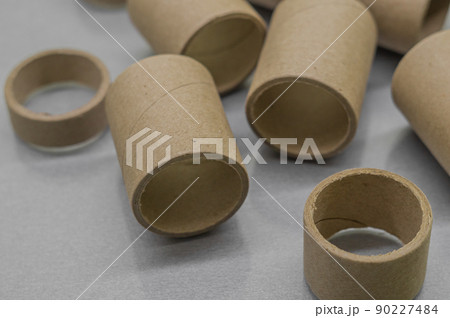 Blurred cardboard spools for winding. Reels made of cardboard. Background of cardboard bobbins. Selective focus Blurred cardboard spools for winding. Reels made of cardboard. Background of cardboard bobbins. Selective focus 90227484