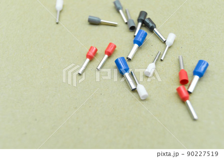 Coloured crimp terminals for different wire sizes. Copper sleeves for crimping electrical cables. Ferrules. Selective focus, copy space Coloured crimp terminals for different wire sizes. Copper sleeves for crimping electrical cables. Ferrules. Selective focus, copy space 90227519