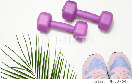 pair of pink sneakers and purple dumbbells on a white background pair of pink sneakers and purple dumbbells on a white background 90228045