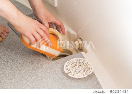 【浴室の排水口を掃除をするミドル主婦】 90234434