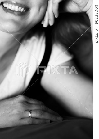 Black and white photo of a beautiful smiling woman. Portrait in vertical execution. Vertical photo. 90235308