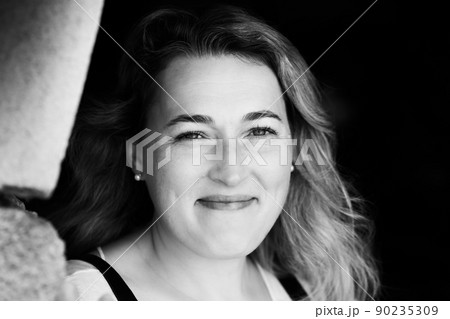 Black and white photo of a woman. A large portrait on a dark background. Front view. 90235309