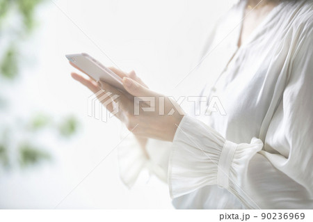 スマホを操作するミドル女性の手元 90236969