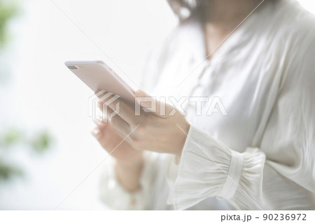 スマホを操作するミドル女性の手元 90236972