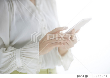 スマホを操作するミドル女性の手元 90236974