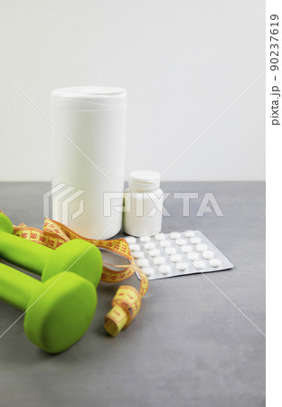 dumbbells on the background of pills. Healthy lifestyle. sports nutrition, doping dumbbells on the background of pills. Healthy lifestyle. sports nutrition, doping 90237619