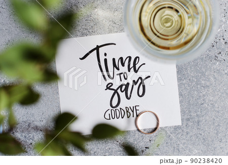 Time to say goodbye. The inscription on a white paper sheet. White wine in a glass glass. Gold engagement ring. Concept - deterioration of relations between people Time to say goodbye. The inscription on a white paper sheet. White wine in a glass glass. Gold engagement ring. Concept - deterioration of relations between people 90238420
