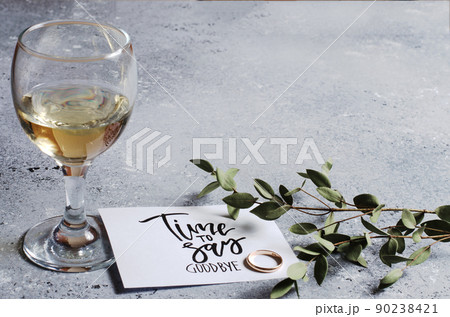 Time to say goodbye. The inscription on a white paper sheet. White wine in a glass glass. Gold engagement ring. Concept - deterioration of relations between people Time to say goodbye. The inscription on a white paper sheet. White wine in a glass glass. Gold engagement ring. Concept - deterioration of relations between people 90238421