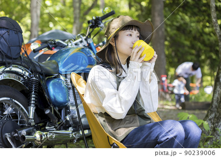バイク女子チェアリングイメージ　湖畔でソロキャンをするバイク女子 90239006