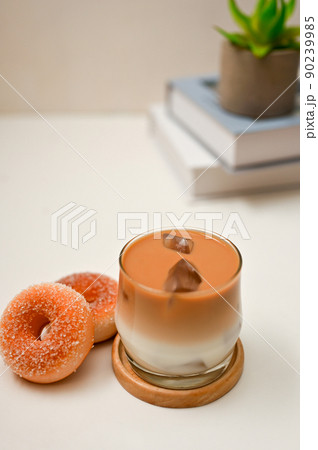 Iced latte, a glass of iced latte with tasty donuts on white office desk Iced latte, a glass of iced latte with tasty donuts on white office desk 90239985