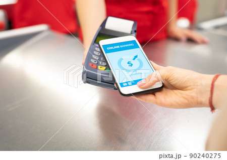 High angle close-up shot of unrecognizable young woman using online banking technology on smartphone to pay for goods in store 90240275
