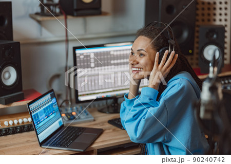 Podcasting, music and radio concept - close-up of African American woman speaking on the radio, working as a presenter Podcasting, music and radio concept - close-up of African American woman speaking on the radio, working as a presenter 90240742