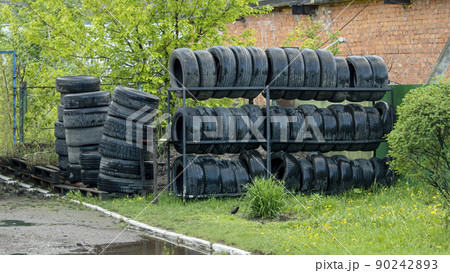 old and wet car tires on a shelf near a car service 90242893