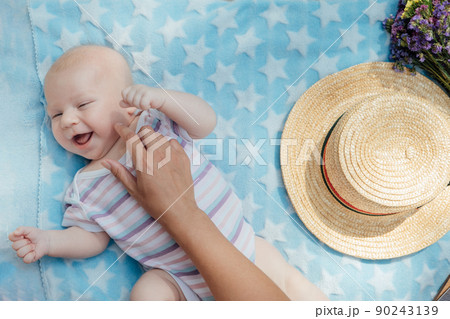 Newborn baby spending time outside. Happy and smiling mother with her newborn baby spending time in the park. Getting fresh air and natural sunlight for babies. Newborn baby spending time outside. Happy and smiling mother with her newborn baby spending time in the park. Getting fresh air and natural sunlight for babies. 90243139