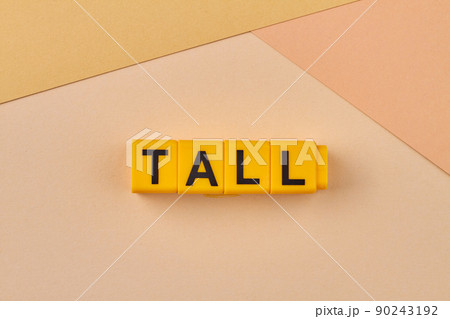 Word tall written on yellow blocks against color background. 90243192