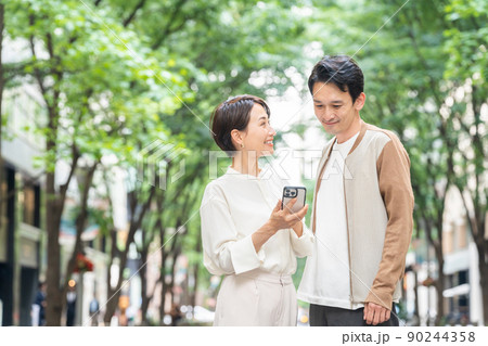 デートをする笑顔のカップル（お出かけ・外出・買い物・夫婦・スマホ・アプリ） 90244358