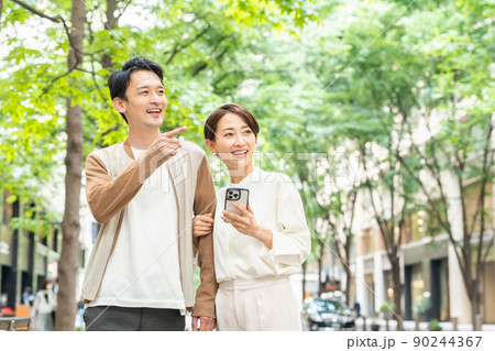 デートをする笑顔のカップル（お出かけ・外出・買い物・夫婦・スマホ・アプリ） 90244367