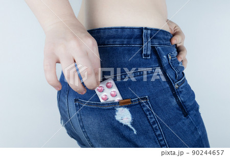 Tablets for pain during menstruation. Pain during menses. The concept of critical days for a woman. The girl stands on a white background and holds medicines for pain in her hands. Painkillers Tablets for pain during menstruation. Pain during menses. The concept of critical days for a woman. The girl stands on a white background and holds medicines for pain in her hands. Painkillers 90244657