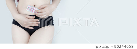 Tablets for pain during menstruation. Pain during menses. The concept of critical days for a woman. The girl stands on a white background and holds medicines for pain in her hands. Painkillers Tablets for pain during menstruation. Pain during menses. The concept of critical days for a woman. The girl stands on a white background and holds medicines for pain in her hands. Painkillers 90244658