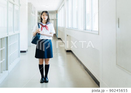 学校の廊下に立つ女子高生 90245655