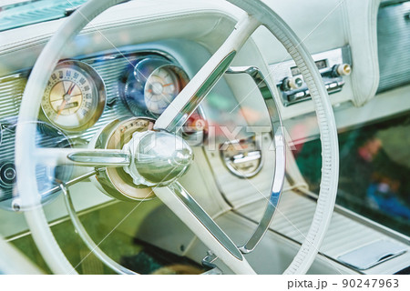 Retro car bright interior, dashboard and steering wheel with controls in classic american car 90247963