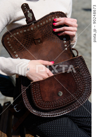 open small brown women's leather bag with a carved pattern. selective focus 90248673