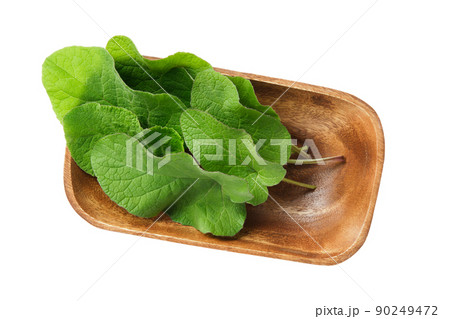 Wooden bowl of green Burdock leaves, isolated on white. Top view. Wooden bowl of green Burdock leaves, isolated on white. Top view. 90249472